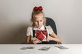 A little girl in a school uniform is counting money - hundred-dollar bills. Teaching children financial literacy Royalty Free Stock Photo