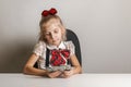 Little girl in school uniform holds a fan of hundred dollar bills. Teaching children financial literacy Royalty Free Stock Photo