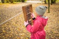 Little girl scores on old mechanical abacus in the autumn park. A child learns to count numbers on a retro calculator. Teaching a Royalty Free Stock Photo