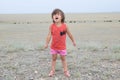 Little girl screaming in big landscape environment. Child emotionally saying loudly, singing a song with expression