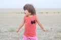 Little girl screaming in big landscape environment. Child emotionally saying loudly, singing a song with expression