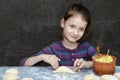 Little girl sculpts patties with potatoes