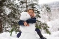 Little girl sculpts snowman in winter Park Royalty Free Stock Photo