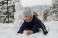 Little girl sculpts snowman in winter Park