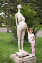 Little girl and the sculpture of pregnant woman