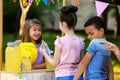 Little girl selling natural lemonade to kids. Summer refreshing drink Royalty Free Stock Photo