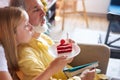 Little girl and senior man blow out the candles on the cake Royalty Free Stock Photo