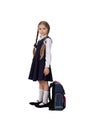 A seven year old school girl in a school uniform poses on a white or light background Royalty Free Stock Photo