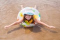 Little girl in shallows lying on his stomach in the inflatable ring outstretched arms and legs Royalty Free Stock Photo