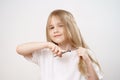 little girl shears her long hair with scissors on a white background. haircut Royalty Free Stock Photo