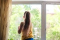 Little girl in shirt and blue shorts washes the windows at home. Daughter with a cat wash the window Royalty Free Stock Photo