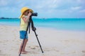 Little girl shooting with camera on a tripod during her summer vacation Royalty Free Stock Photo