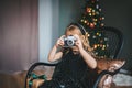 Little girl shooting photo with vintage camera near Christmas tree Royalty Free Stock Photo