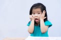 Little girl showed a crazy face with a hard learning curve. Cute child pushed his cheek  gasped. Royalty Free Stock Photo