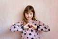 Little girl is showing heart from fingers