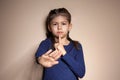 Little girl showing HUSH gesture in sign language on background
