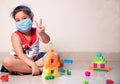 Little Girl showing Winning Sign in fight against Coronavirus with mask on face