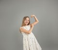 A little girl shows her strength. A beautiful young girl demonstrating the strength of her arms poses in a light light