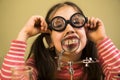 Little Girl Shows her teeth in Magnifier. Child Scientist