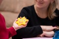 Little girl shows mom just crafted art toy from perler beads, beautiful smiled star. Fusible colorful beads. Toy that develops the