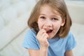 Little girl shows a reeling tooth. changing milk teeth to indigenous teeth.