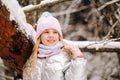 a little girl in a silver jacket in winter goes outside in winter