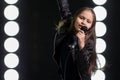 Little girl singing in front of stage lights Royalty Free Stock Photo