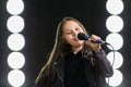 Little girl singing in front of stage lights