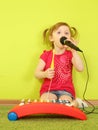 Little girl singing into a Royalty Free Stock Photo