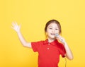 little girl singing on yellow background Royalty Free Stock Photo