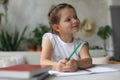 Little girl sit at desk, writing in notebook, do exercises at home, little child handwrite prepare homework