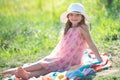 Little girl sit on green grass in summer park. Funny kids emotions. Outdoor close up portrait of a cute little child Royalty Free Stock Photo