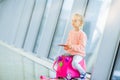 Adorable little girl in airport with her luggage waiting for boarding Royalty Free Stock Photo