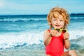 Little girl sit with sunglasses and smile on the beach over sea Royalty Free Stock Photo