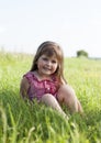 Little girl siting on the green grass