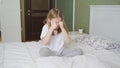 a little girl sits on a bed in the bedroom and cries.