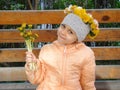 Little girl sits on bench with floral wreath on her head Royalty Free Stock Photo