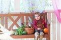 Little girl sits on a bench on a terrace