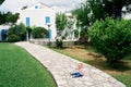 Little girl sits on a cobbled path in the garden in front of the house Royalty Free Stock Photo