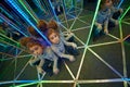 Little girl sits at crossing in mirror labyrinth Royalty Free Stock Photo