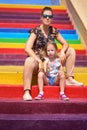 little girl sits on the edge of the wall dangling legs, stone wall her legs dangling in the air Royalty Free Stock Photo