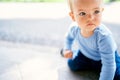 Little girl sits on her knees on the tile. Close-up. Portrait Royalty Free Stock Photo