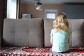 Little girl sits with an offended back on the couch