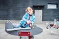 A little girl sits on a swing in the shape of an airplane. The child is playing on the playground Royalty Free Stock Photo