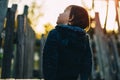 little girl sits on a wooden slide with her back and looks at the sky Royalty Free Stock Photo