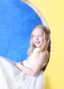 Little girl sits on a yellow moon. Royalty Free Stock Photo