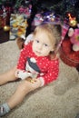 Little girl sitting against Christmas decoration