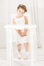 Little girl sitting alone at white table cafe Royalty Free Stock Photo