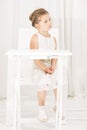 Little girl sitting alone at white table cafe Royalty Free Stock Photo