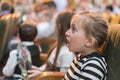 little girl sitting on armchairs at cinema or in the theater. The girl with great interest in the theater. Beautiful little girl Royalty Free Stock Photo